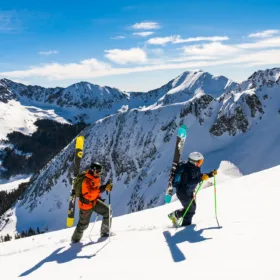 Two skiers hiking up a snowy mountain in St. Anton am Arlberg.